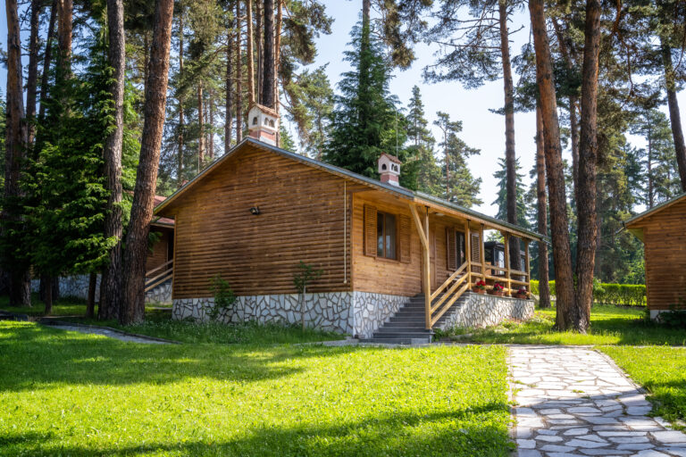 One-story wooden bungalows with a veranda in a beautiful mountain village among ancient trees near Bansko, Bulgaria